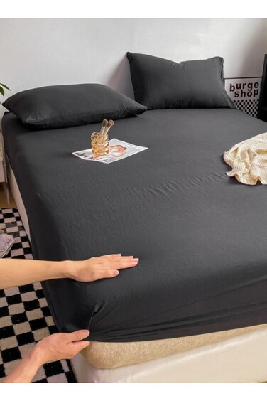 Home 3-Piece Set: single-size fitted bedsheet and two pillowcases, washable cotton in a black color.