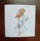 Lady holding her hat on a windy day note card